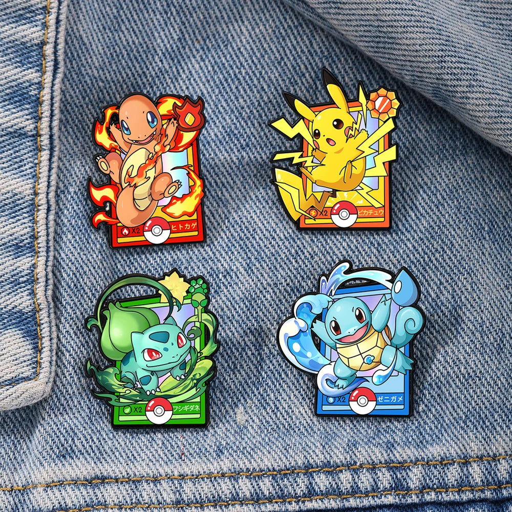 A set of four cartoon enamel pins featuring Pokémon characters on a denim fabric background.