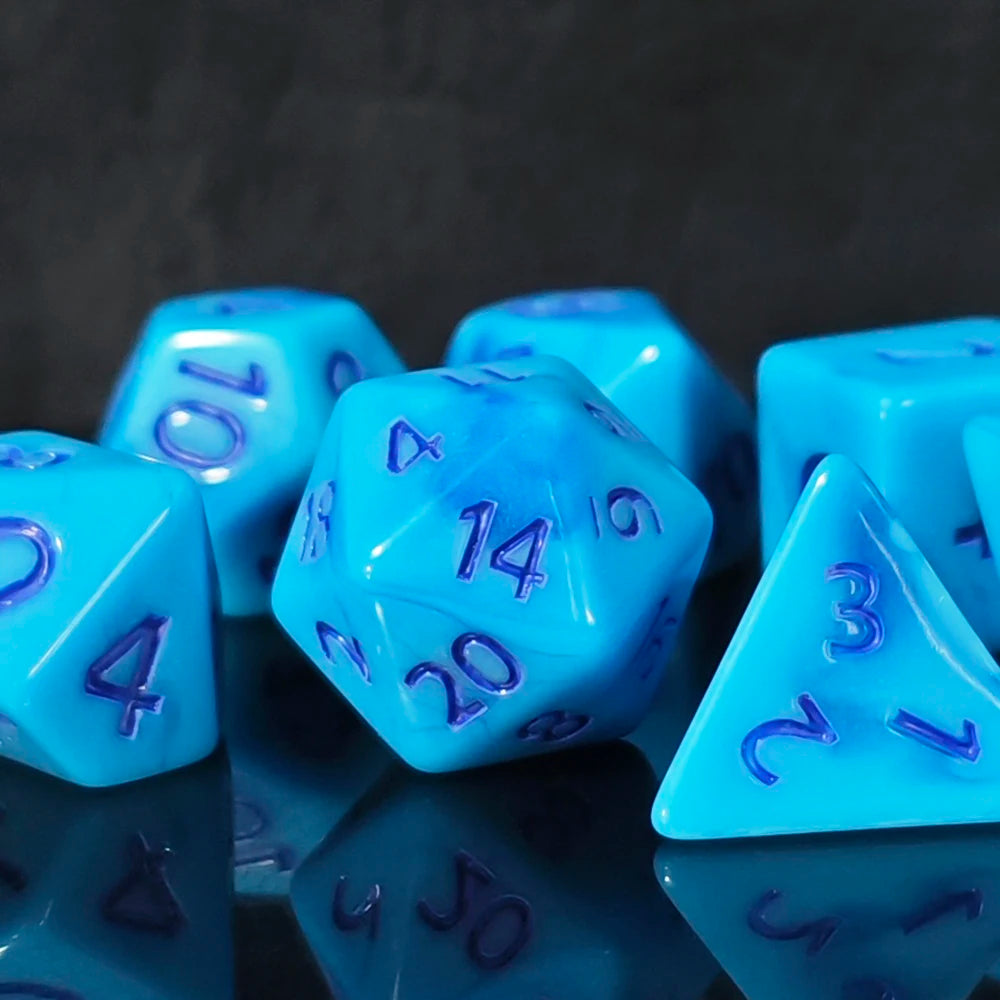 A close-up of a set of seven polyhedral dice with deep blue ink, including a d4 and a triangle, reflecting on a dark surface.