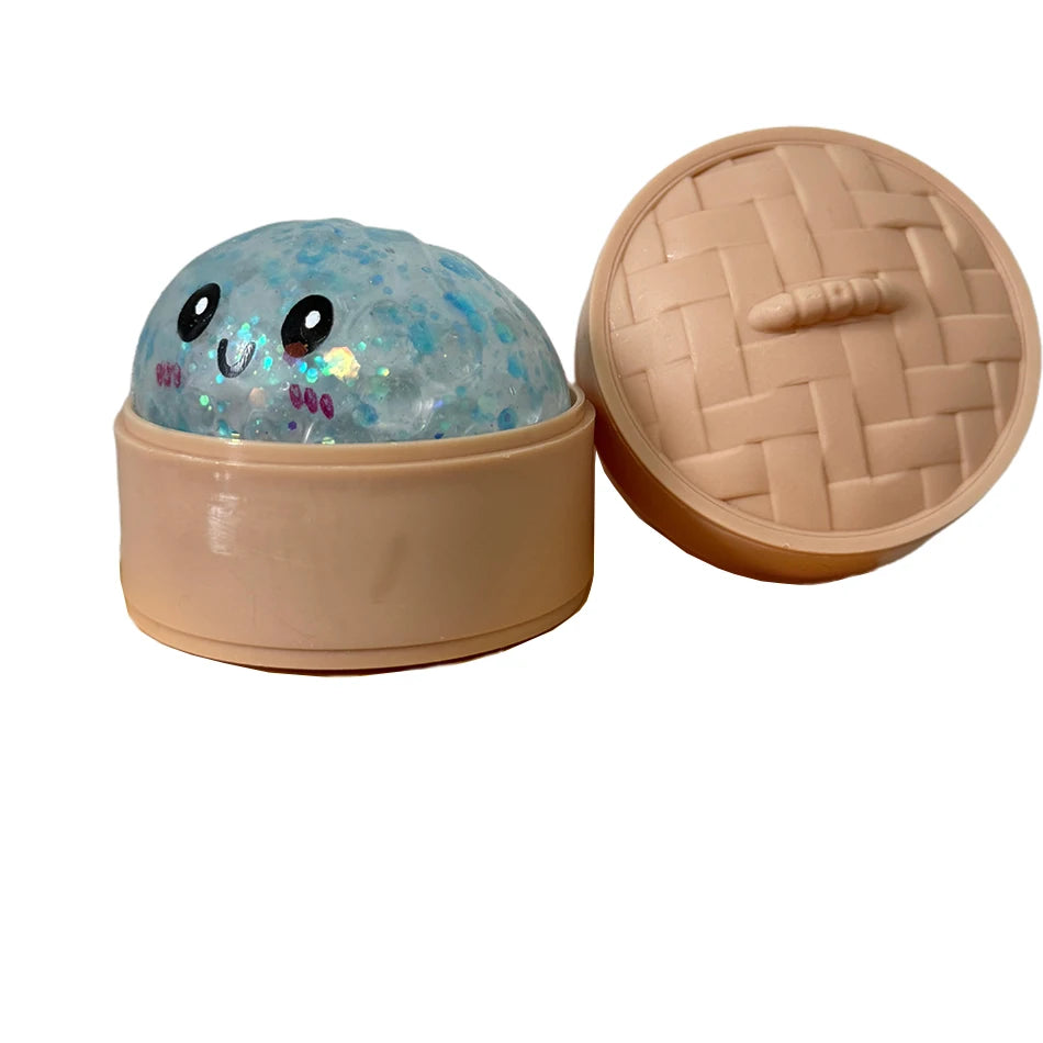 Runder, durchsichtiger blauer Glitzer-Squishy-Spielzeug in einem beige Behälter mit passender Deckel.