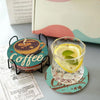 A set of eight DIY diamond art coasters with a holder and a glass coaster featuring a lemon slice.