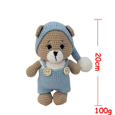 A handmade crochet stuffed bear in light blue and brown yarn, shown with a height and weight measurement.