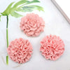 Three pink floral 3D silicone molds for candles, soap, and baking displayed on a white surface with green leaves.