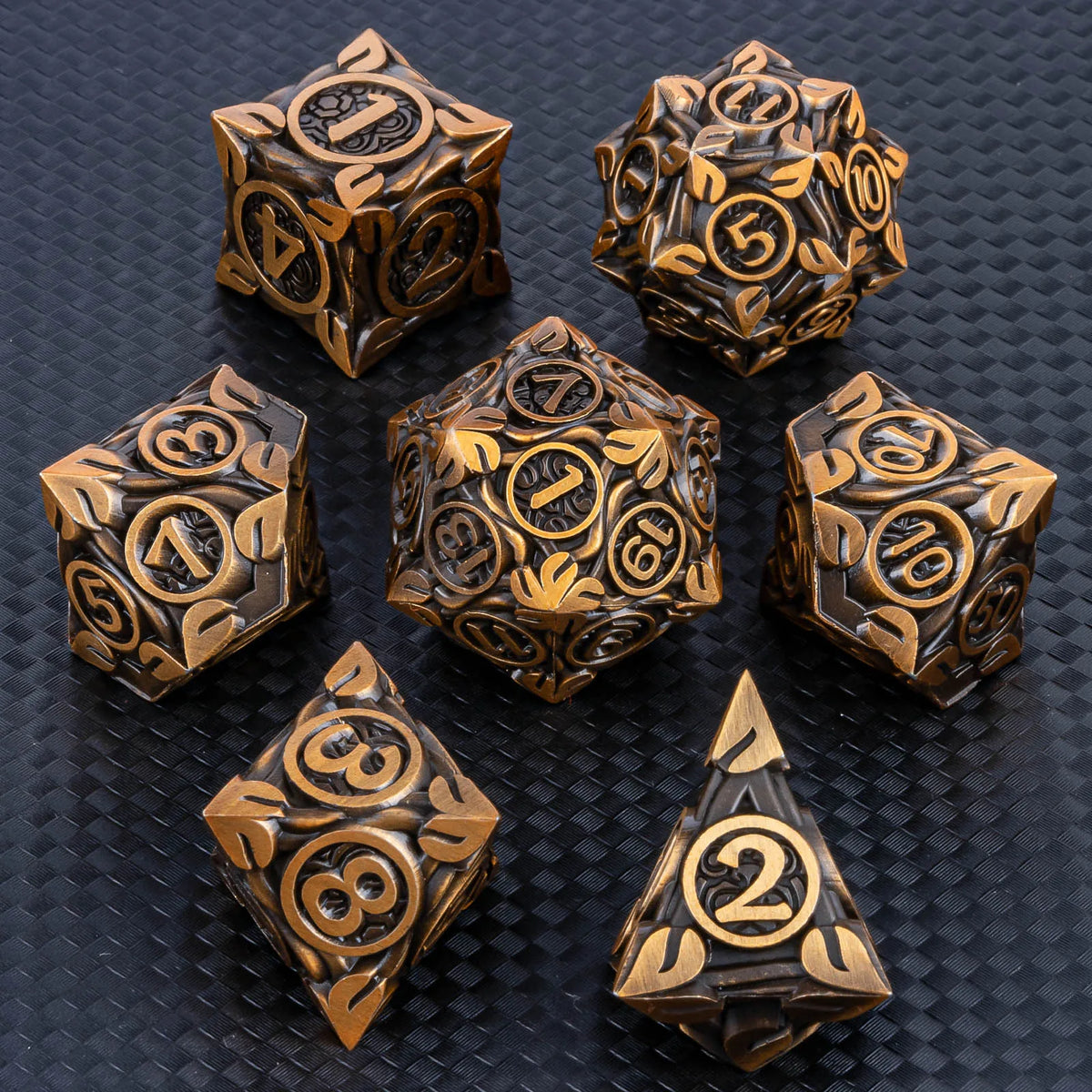 A set of ten premium zinc alloy metal dice in gold and black finishes arranged on a dark surface.