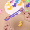 A hand holds a purple sensory stress bracelet next to various colored dinosaur and animal figurines on a white plate.