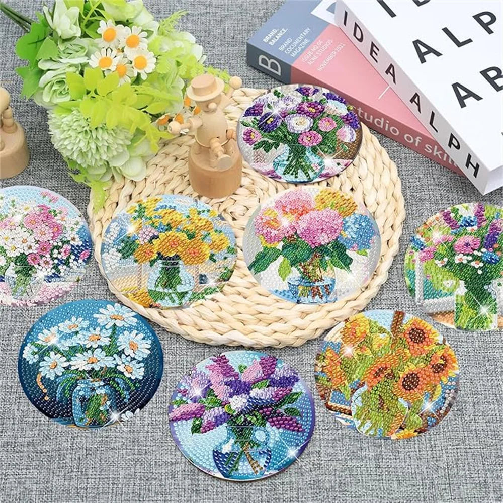 A collection of eight diamond painting coasters featuring floral designs and various colors, displayed on a woven mat.