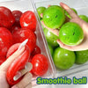Hands hold and display a variety of smooth, spherical kiwi and watermelon smoothie balls in a clear container.
