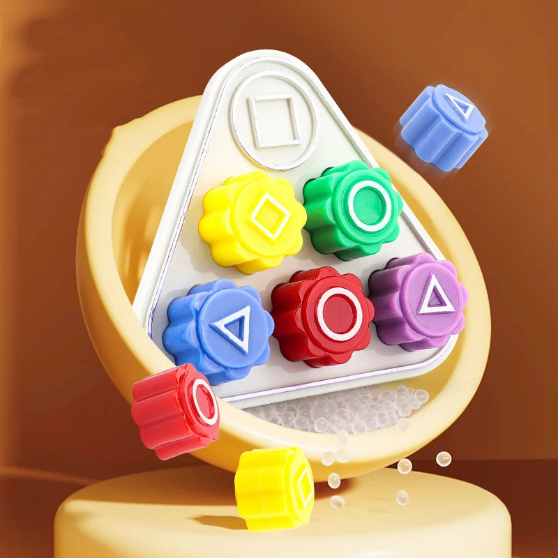 A set of five colored gonggi stones arranged in a white triangular holder on a yellow base.