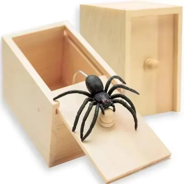 Une boîte en bois avec une fente contenant une araignée noire, utilisée comme gadget de farce.