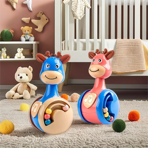 A colorful fawn sliding rattle toy with horns and a body is shown on a soft rug.