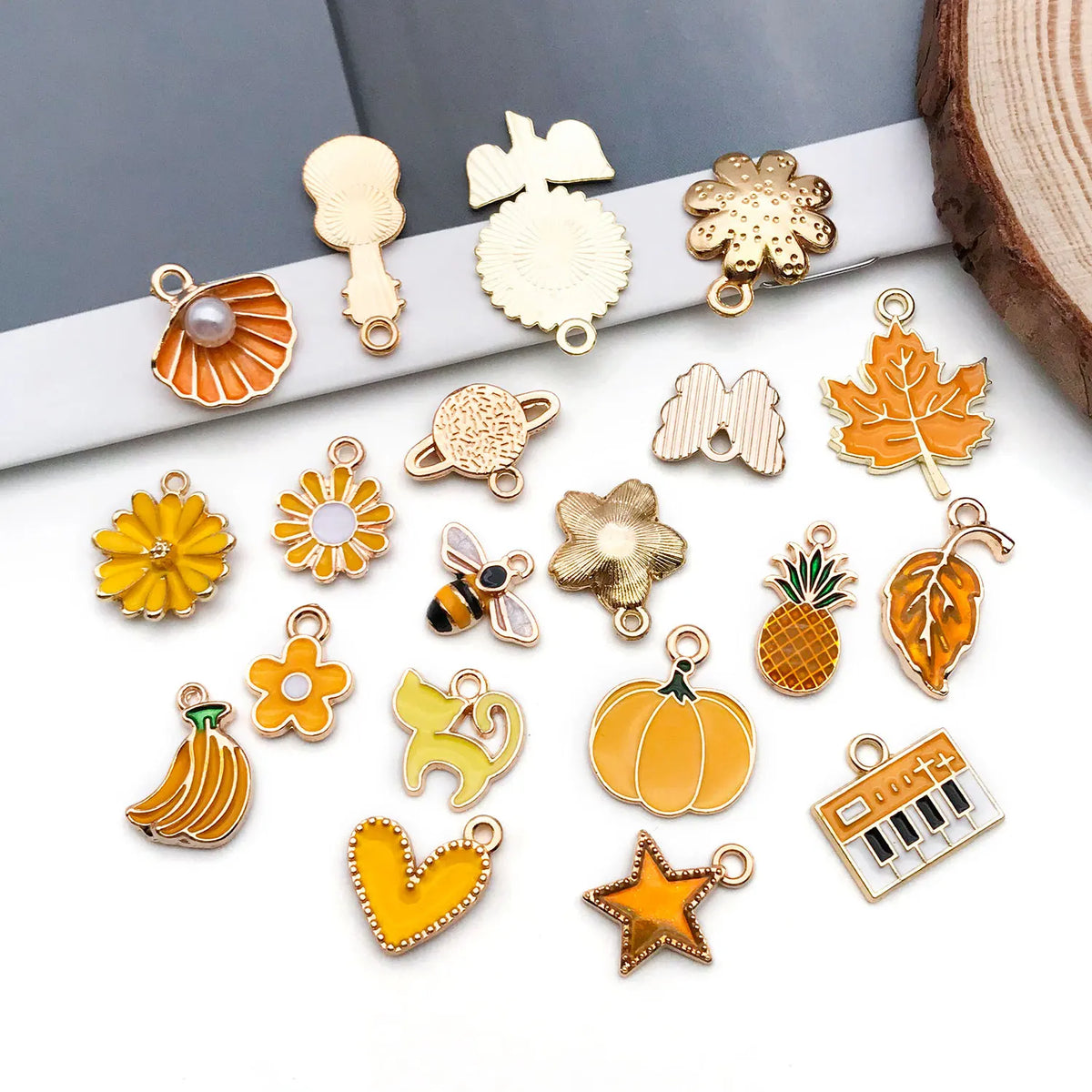 A collection of gold and orange enamel alloy flower charms for DIY jewelry making.