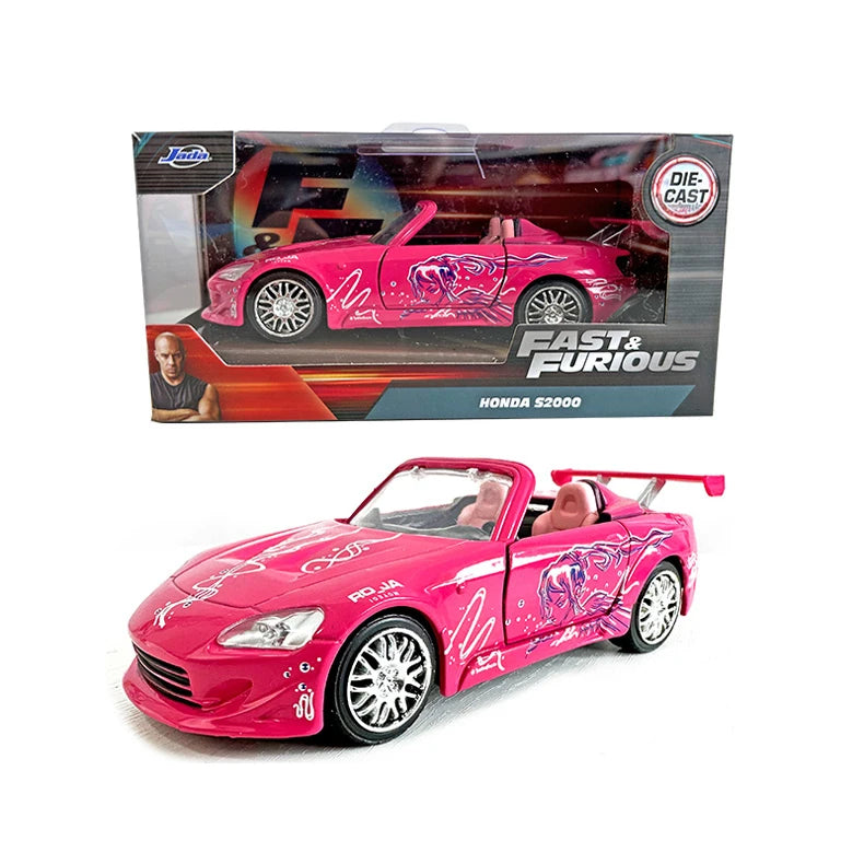 A pink diecast model of a Ford Mustang convertible is shown next to its packaging.