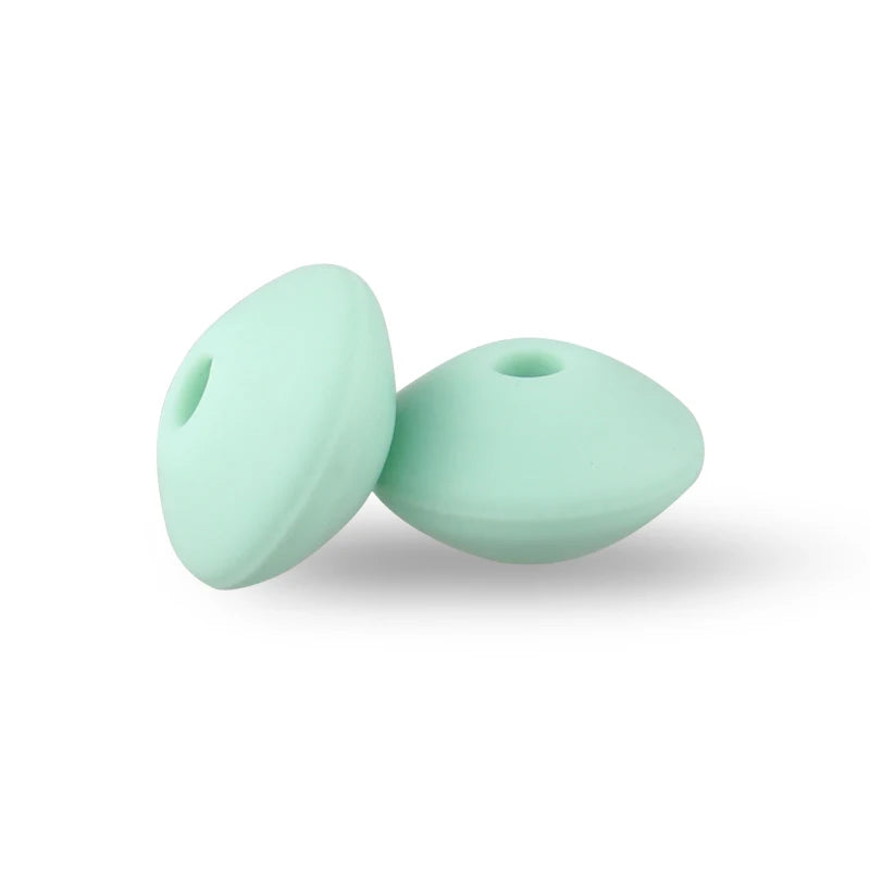Two smooth, light mint green silicone lentil beads shaped like an abacus for jewelry making