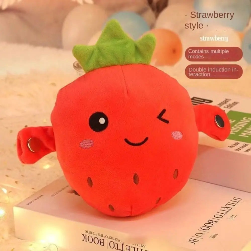 An orange strawberry plush toy with a green leafy top is displayed on a box.
