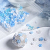 A pile of blue and white camellia resin bowknot shakers and small flowers on a white surface.