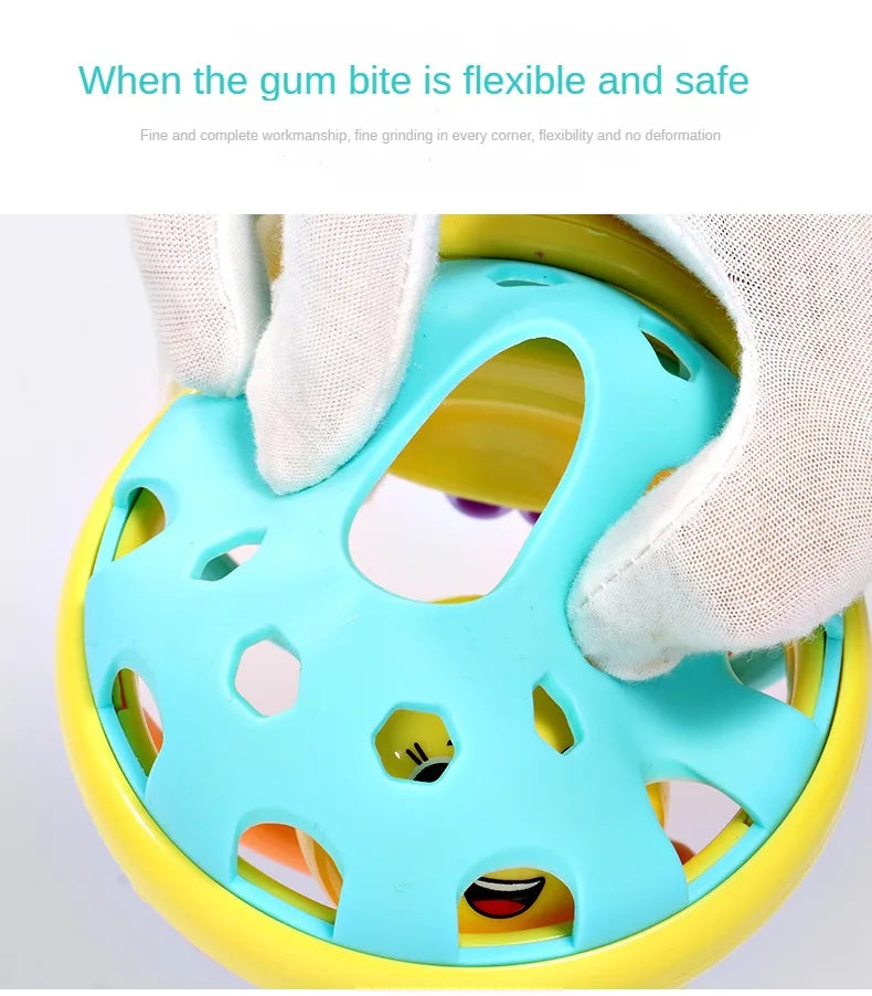 A hand is holding a light blue sensory catch ball rattle toy with yellow accents, showing its flexible and safe design.