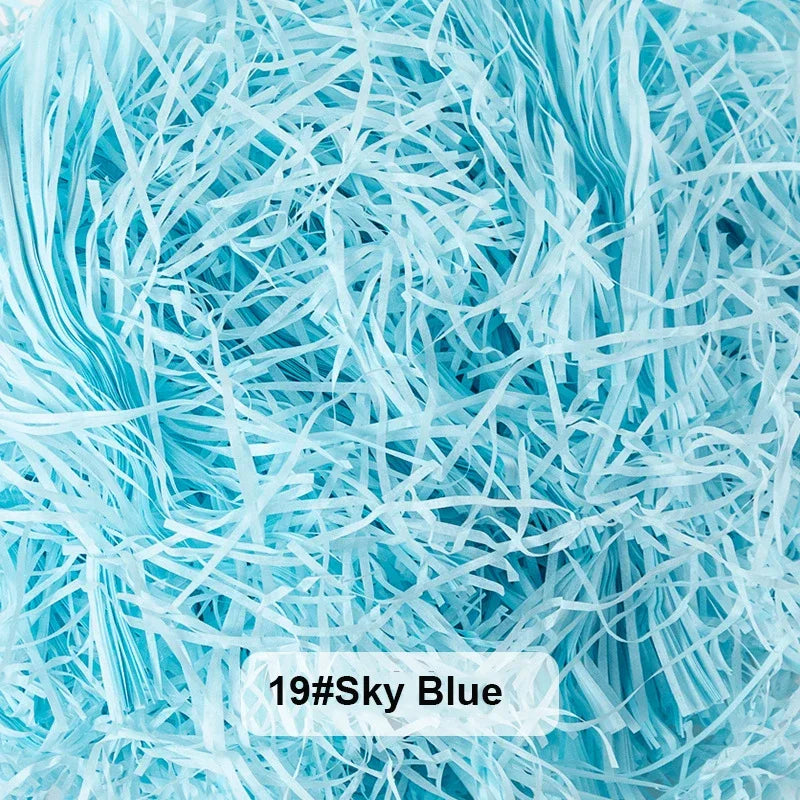 A close-up view of light blue raffia paper shreds used for gift boxes and baskets.
