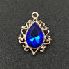 Gold plated water droplet charm featuring a deep blue crystal rhinestone set in an ornate flower design.