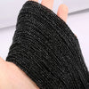 A close-up of black faceted natural stone beads threaded onto a string, shown on a hand.