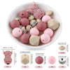A bowl filled with pink and beige silicone beads shaped like cartoon animals for DIY jewelry making