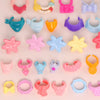 A collection of ten mini pet collar accessories in various colors and shapes for animal figurines.