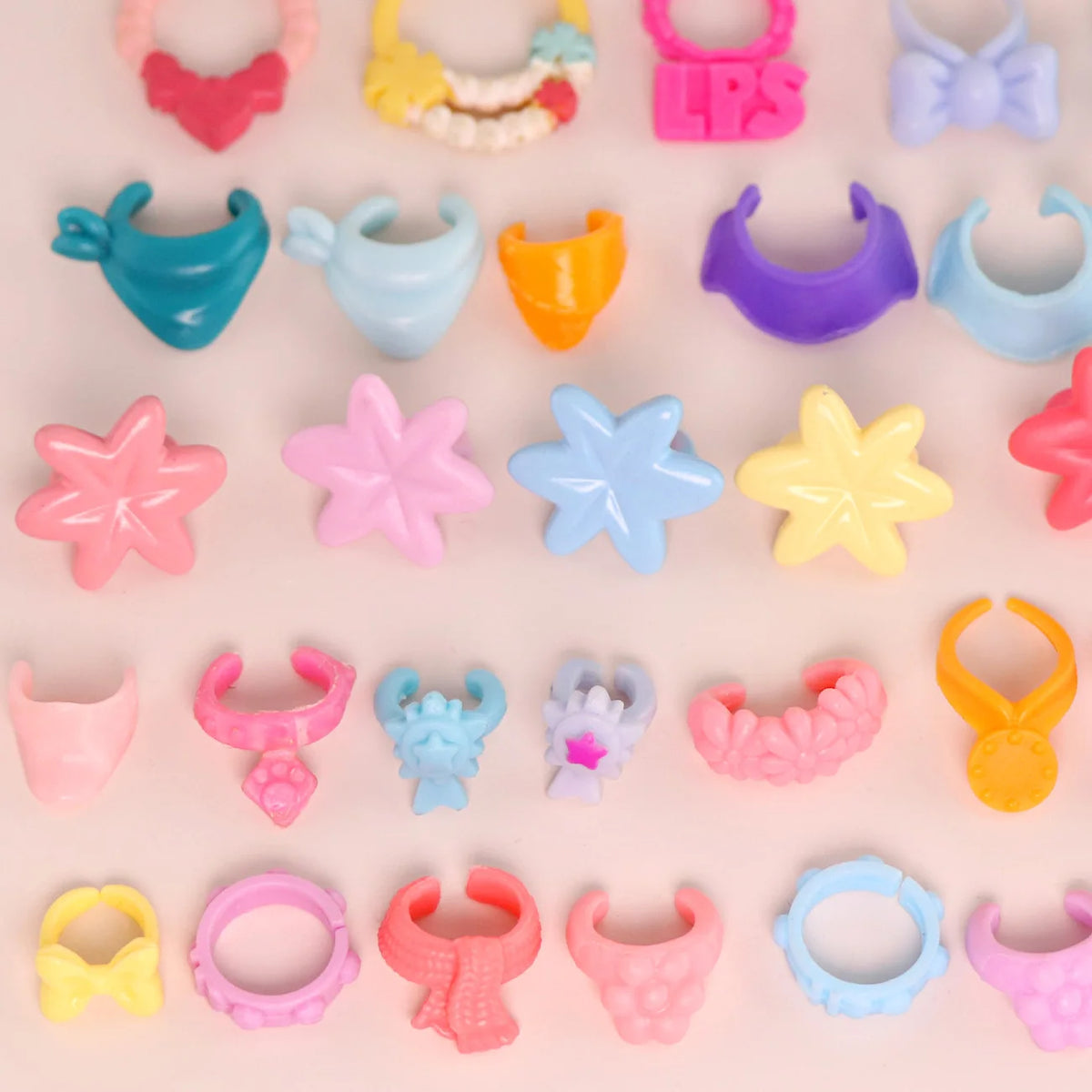 A collection of ten mini pet collar accessories in various colors and shapes for animal figurines.