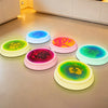 Colorful interactive LED balance stone mats displayed on a light floor.