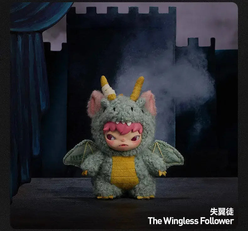 A plush doll resembling a small, gray, horned creature with pink accents is displayed in front of a dark castle backdrop.