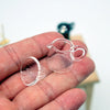 A hand holds a clear glass miniature hand-brewed coffee stand set for dollhouse