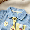 A light blue baby boy short-sleeve romper featuring yellow and white appliqués of a bear and a mushroom.