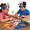 Two children play Guess Who I Am using family card board game pieces and a blue headband.