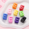 Colorful acrylic letter beads in various shades of orange, pink, yellow, green, and red arranged on a white tray.