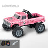 Pink alloy remote control truck with large tires and a controller and battery.