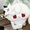 A white plush pendant collectible doll with pink accents and a green fabric background.