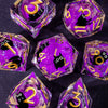 A set of handmade liquid core resin dice featuring purple and gold colors with sharp edges.