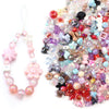 A loose pile of colorful acrylic bow beads in various shades of pink, purple, blue, and clear, used for DIY jewelry making.