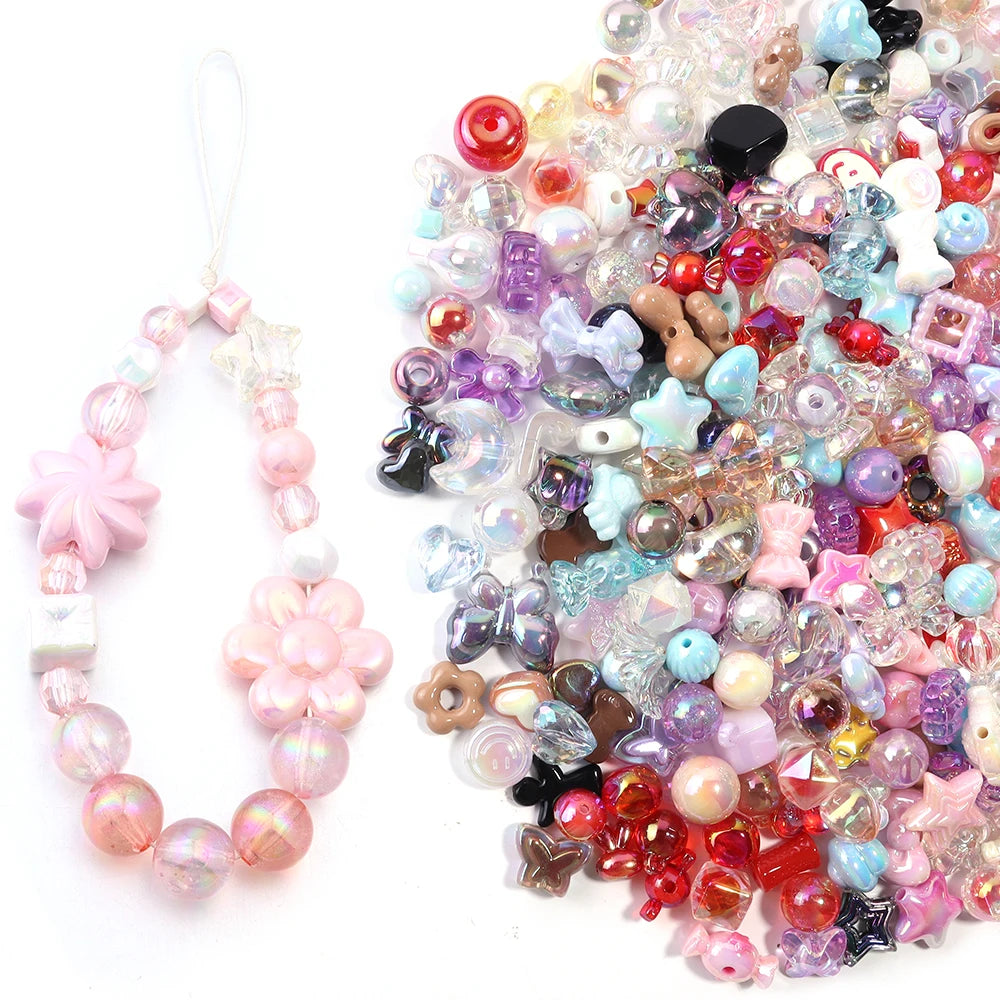 A loose pile of colorful acrylic bow beads in various shades of pink, purple, blue, and clear, used for DIY jewelry making.