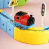 A red magnetic train engine is placed on a yellow track section next to a white light switch.