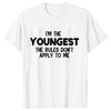 A white t-shirt with black text that reads I'm the youngest the rules don't apply to me