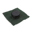 A small black tin of premium natural rosin for string instruments resting on a dark green cloth.