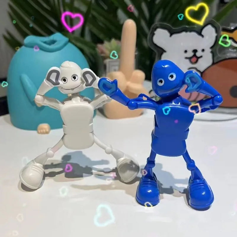 A white wind-up dancing robot toy and a blue wind-up dancing robot toy are displayed on a white surface.