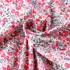 Pink and gray floral fabric in a gathered, ruched texture for clothing.