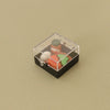 A clear plastic box contains miniature Japanese sushi items including a jar and various colored food pieces for a dollhouse k