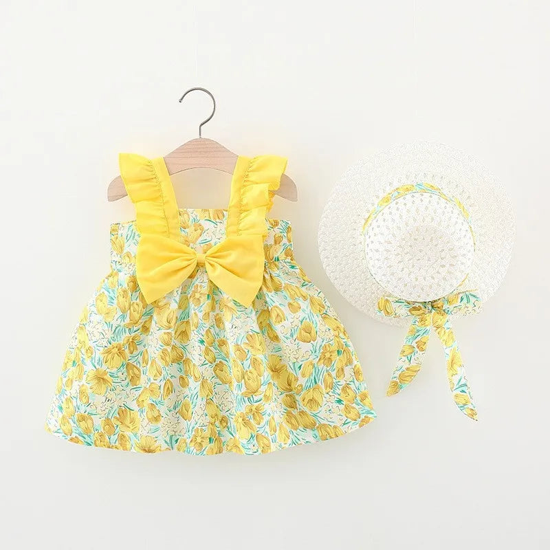 A yellow floral print baby girl summer dress with a bow and a white sunhat with a yellow ribbon