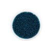 A clear container filled with dark teal glass seed beads for jewelry making