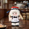 A fluffy white plush keychain of a character wearing a chef's hat and apron in an izakaya setting.