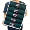 A pack of five skeins of dark green alpaca wool yarn for knitting and crochet projects.