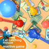 A collection of cat and mouse themed board game components including a blue ball, red and yellow toys, and game cards.