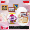 A yellow ZURU Mini Brands create surprise ball collectible surrounded by various framed products and a magnifying glass.