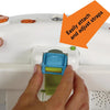 A hand is attaching or adjusting a teal strap on a white ocean-themed crib soother device.