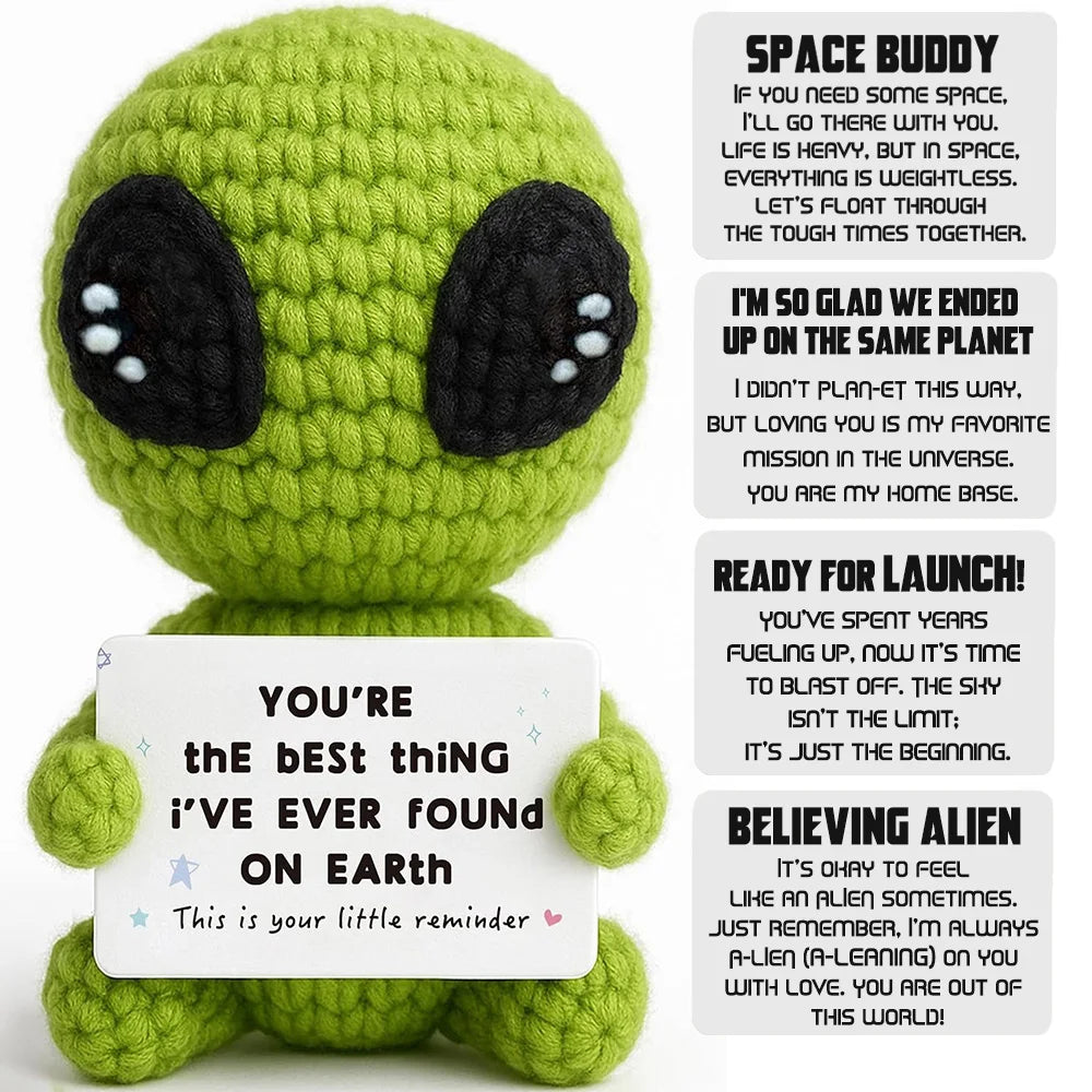 Handmade crochet alien plush toy in lime green with black eyes and a sign